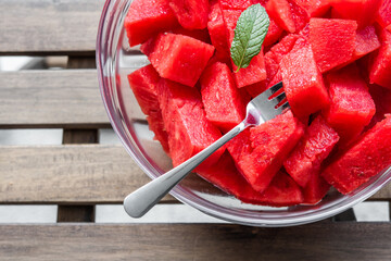 Organic watermelon cut in a glass bowl, with several forks, fresh fruit, dessert, full of vitamins and antioxidant.