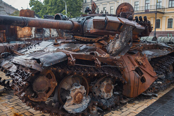 Fototapeta na wymiar Destroyed Russian tank in the rain. Rusty broken military equipment in the rain