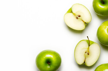 Whole and sliced green apples on white background with copy space.