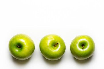 Three green apples on white background with copy space.