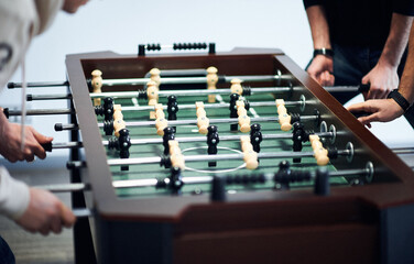 group of young people playing table football at office