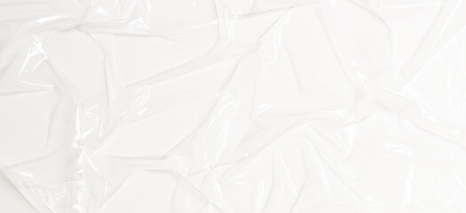 Wrinkled plastic wrap on white color background. Crumpled transparent plastic cellophane. Reflecting light and shadow on creases and folds in plastic surface. Texture overlay effect template