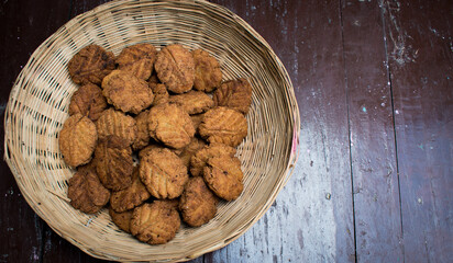 Thekua , an Indian sweet dish or a snacks in wooden basket.It is popular in bihar and jharkhand .Prashad in chhat festival. selective focus, copy space.