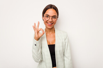 Young hispanic woman isolated on white background winks an eye and holds an okay gesture with hand.