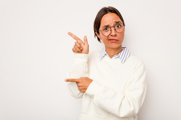 Young hispanic woman isolated on white background shocked pointing with index fingers to a copy space.