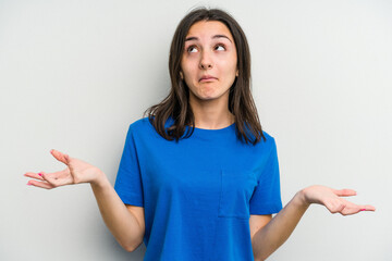 Young caucasian woman isolated on white background doubting and shrugging shoulders in questioning...