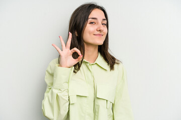 Young caucasian woman isolated on white background cheerful and confident showing ok gesture.