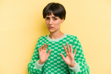 Young caucasian woman with a short hair cut isolated rejecting someone showing a gesture of disgust.