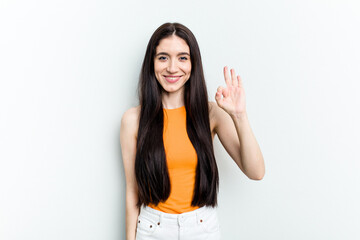 Young caucasian woman isolated on white background cheerful and confident showing ok gesture.