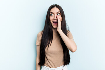 Young caucasian woman isolated on blue background shouting excited to front.