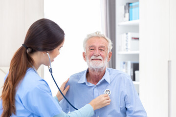 Fototapeta premium happy senior male patient health check and takecare by young female doctor or nurse at home after retirement for good health