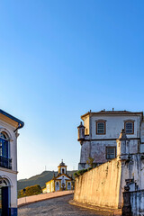 Fototapeta na wymiar Entrance street to the city of Ouro Preto with cobblestones, its churches and historic buildings from the time of the empire in Brazil