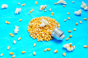 Fototapeta na wymiar Light bulb made from pop corn kernels on blue