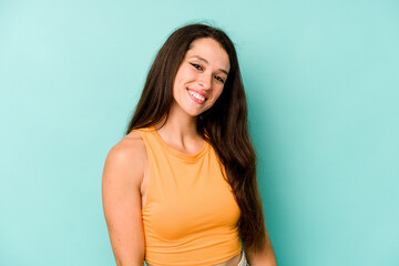 Fototapeta premium Young caucasian woman isolated on blue background confident keeping hands on hips.