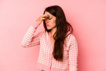 Young caucasian woman isolated on pink background having a head ache, touching front of the face.