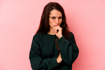 Young caucasian woman isolated on pink background thinking and looking up, being reflective, contemplating, having a fantasy.