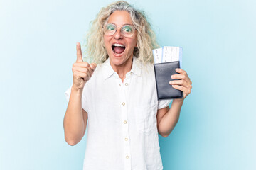 Middle age caucasian woman holding a passport isolated on white background having an idea, inspiration concept.