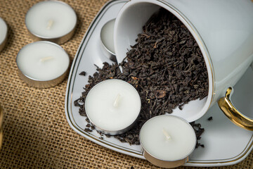 Tea candle in a cup with loose tea. Aromatic tea candle.
