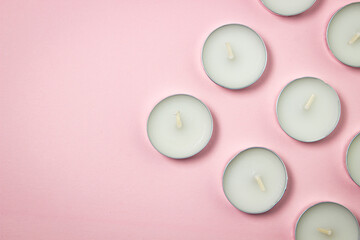 Tea candles on a pink background. Set of tea lights.