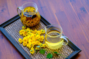 Jug Glass Of Chrysanthemum Juice On Wooden Terrace