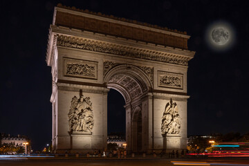 Fototapeta na wymiar Paris, France - 08 12 2022: Place Charles de Gaulle. L'Arc de Triomphe with the super moon by night