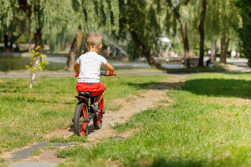 little boy riding a bike in a city park