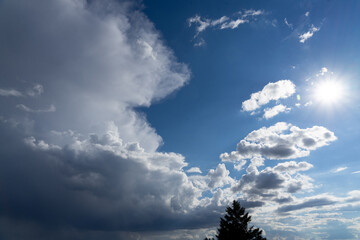 Thunderstorm clouds towering in a bright blue summer sky