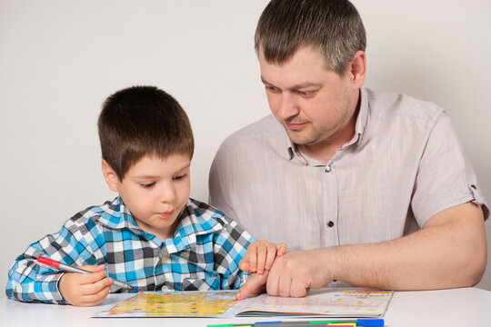 Father and son go through labyrinths, perform tasks for logic and the development of thinking in preparation for school.