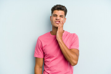 Young caucasian man isolated on blue background having a strong teeth pain, molar ache.