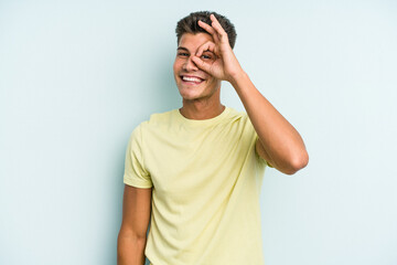 Fototapeta na wymiar Young caucasian man isolated on blue background excited keeping ok gesture on eye.