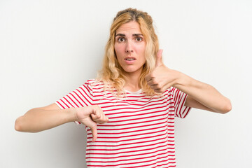 Young caucasian woman isolated on white background showing thumbs up and thumbs down, difficult...