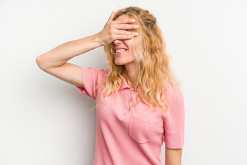 Young caucasian woman isolated on white background covers eyes with hands, smiles broadly waiting for a surprise.