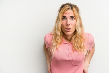 Young caucasian woman isolated on white background being shocked because of something she has seen.