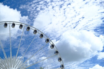 White ferris wheel and cloudy sky