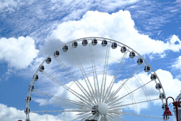 White ferris wheel and cloudy sky