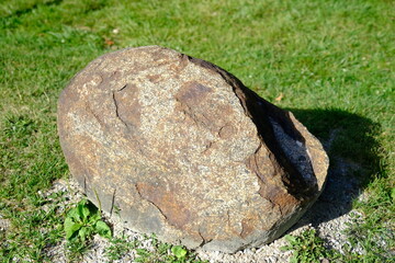 A big rock(stone) on green grass