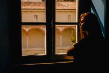 Fototapeta premium woman looking trough window shadows 