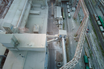 Cement plant with high factory structure and tower cranes at industrial production area. Manufacture, global industry and air pollution concept