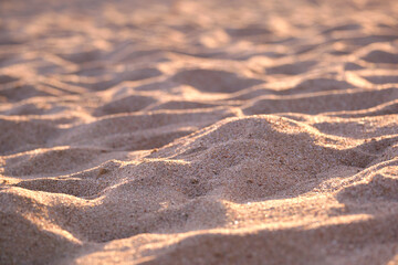 Close up of clean yellow sand surface covering seaside beach illuminated with evening light. Travel and vacations concept