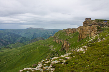 Panoramic view of green mountains and hills from the Bermamyt plateau in Karachay-Cherkessia in Russia on a cloudy summer day and a space for copying