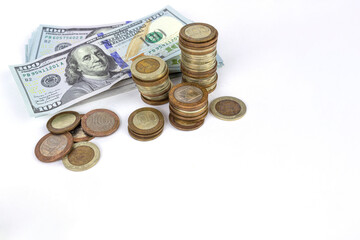 Selective focus of coins stacks and dollar banknotes on white background.