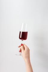 female hand with red wine on white background