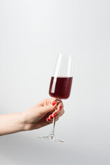 female hand with red wine on white background