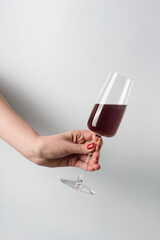 female hand with red wine on white background