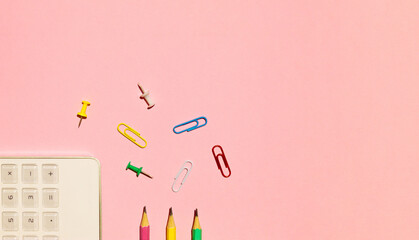 School calculator, pencils and paper clips on pink background. Back to school concept. Flat lay,...