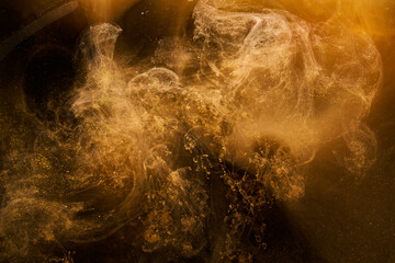 Liquid fluid art abstract background. Ocher jets and smoke rings dancing acrylic paints underwater,...