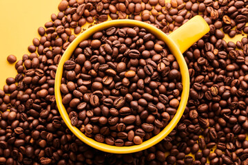 Fototapeta premium Cup of freshly brewed roasted coffee beans on yellow background