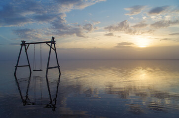 Swing. Salty sunset on lake Elton. Is 18 m below sea level. Is largest mineral lake in Europe and one of most mineralized in world. Russia, Volgograd Oblas