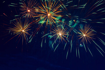 Fototapeta na wymiar Colorful fireworks in the night sky. Festive pyrotechnics. Background image.