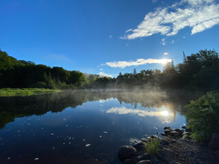 Paysage calme d'une forêt et d'une rivière sous un ciel bleu. Reflet d'une montagne sur un lac le...